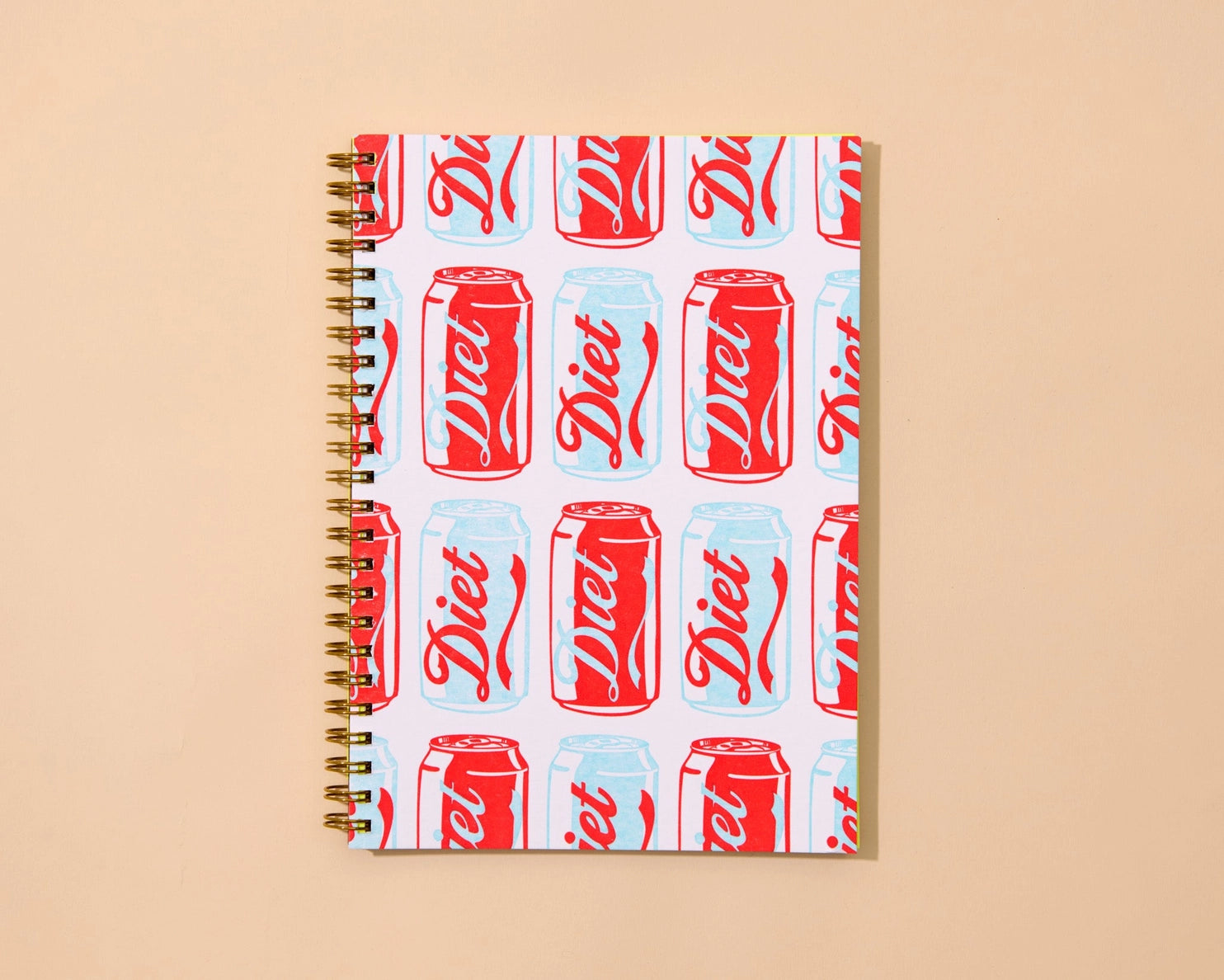 Notebook with Diet Coke can pattern on a beige background