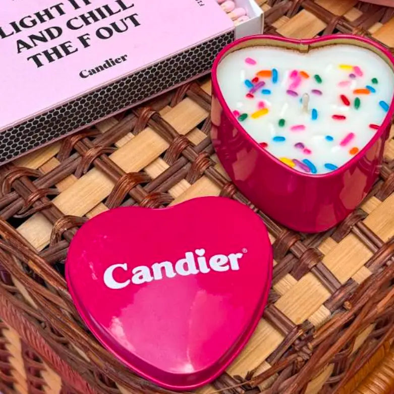 Heart-shaped pink candle with colorful sprinkles and &