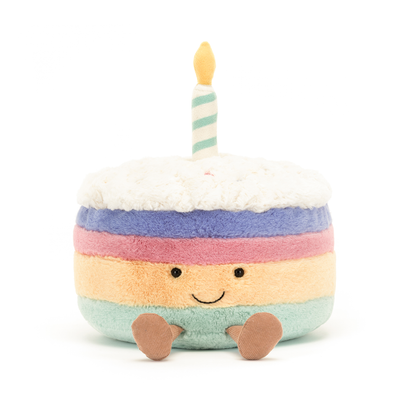 Pastel-colored plush cake toy with a candle on a white background