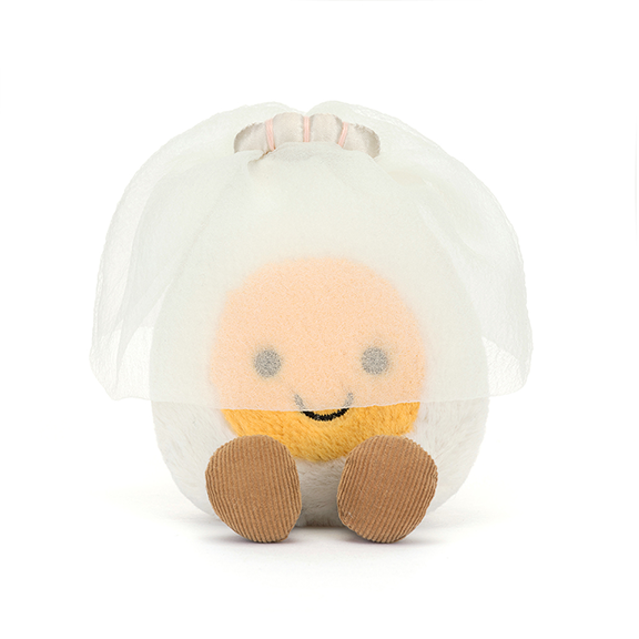 Round plush egg with a smiling face  wearing a bridal veil on a white background