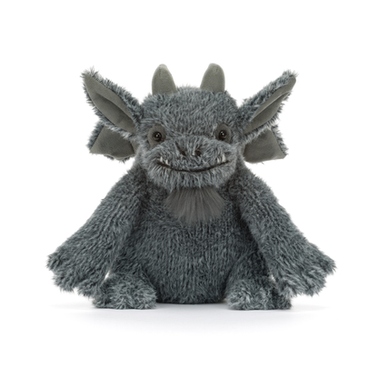A gray plush dragon toy with large pointed ears, small horns, and a stitched smiling face, photographed against a clean white background.