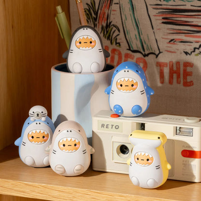 Multiple shark figures in pastel colors (blue, pink, yellow, gray, white) with cartoon faces.