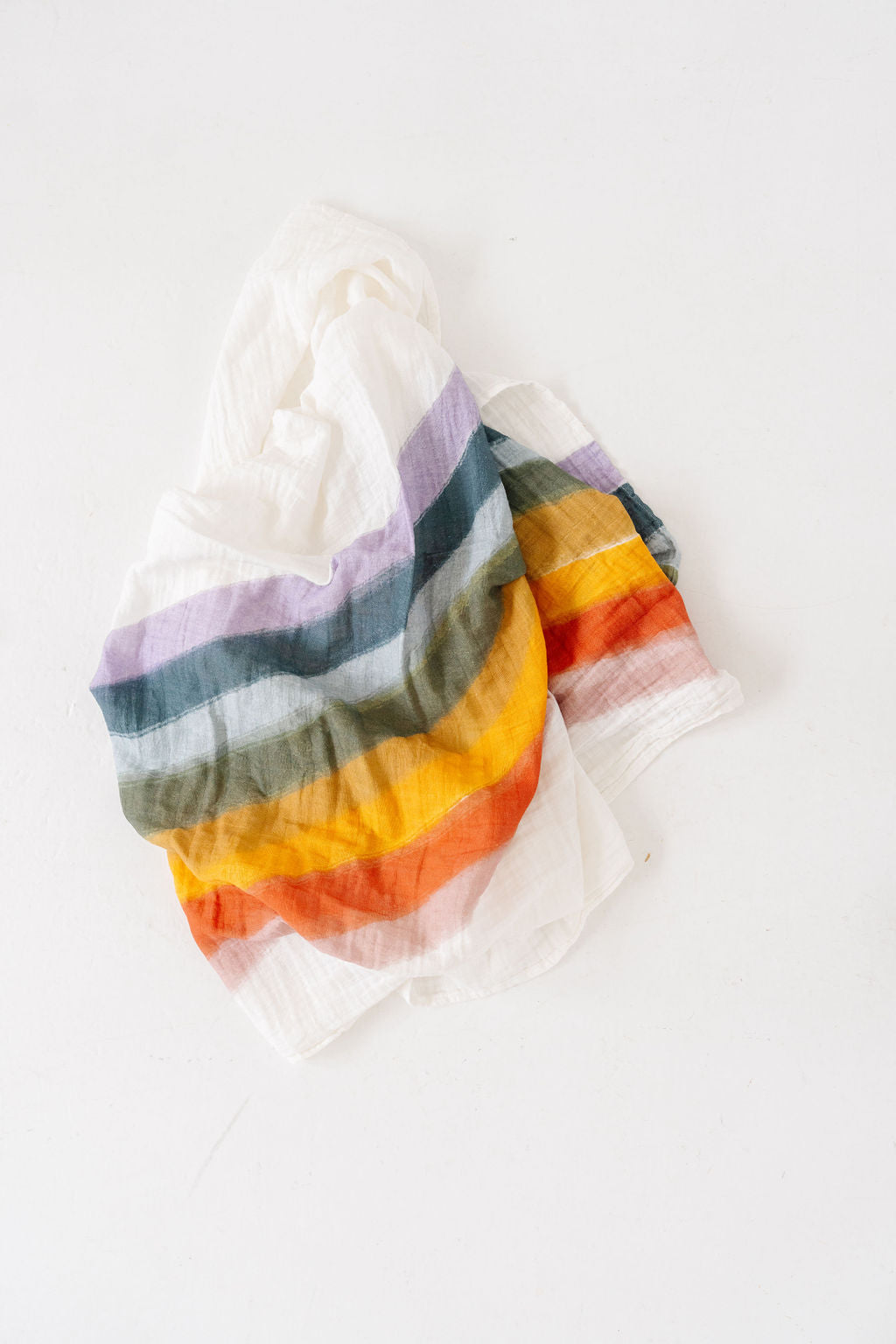 Colorful rainbow swaddle blanket on a white background