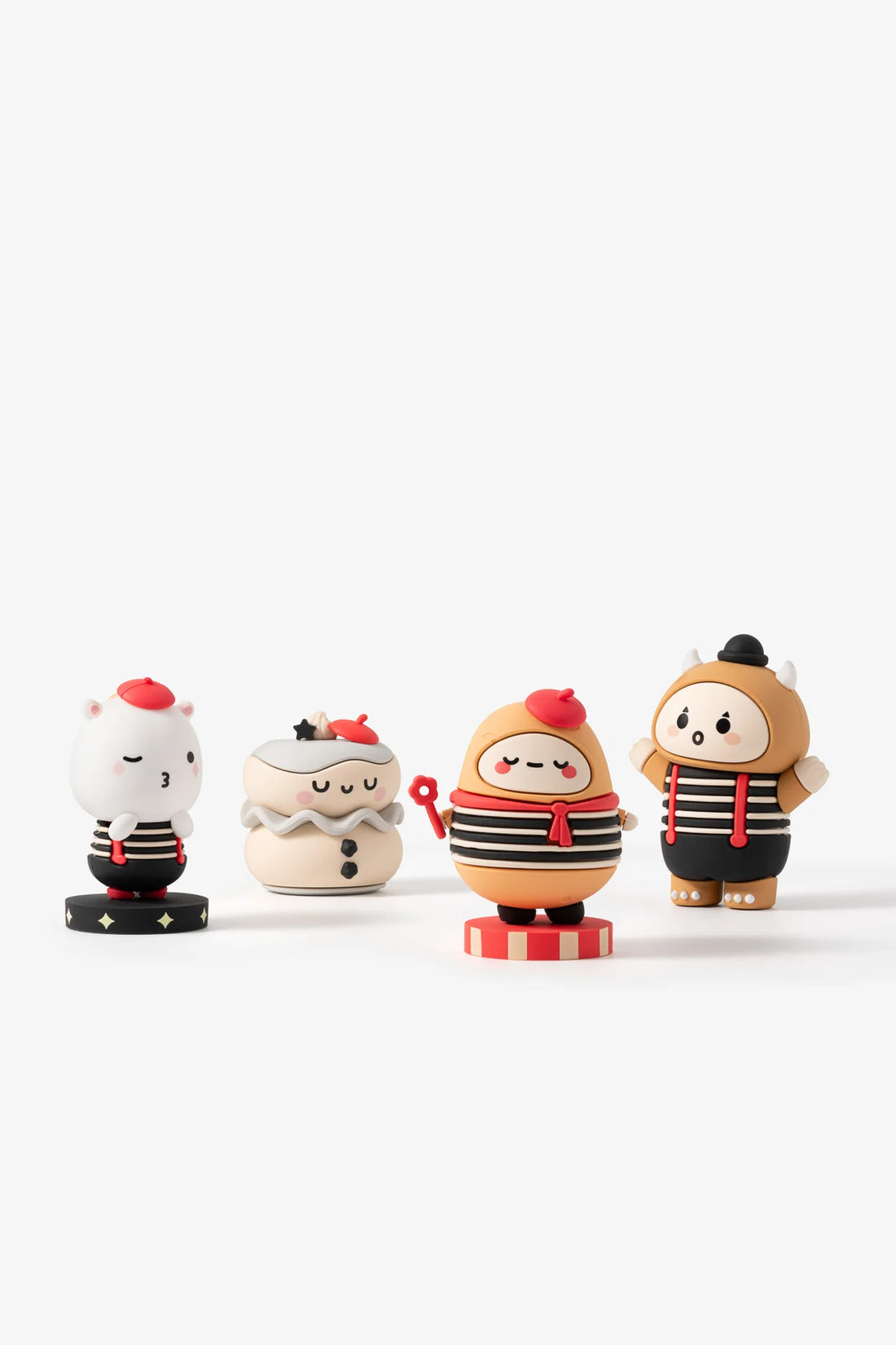 Four small mime figurines with different outfits on a white background