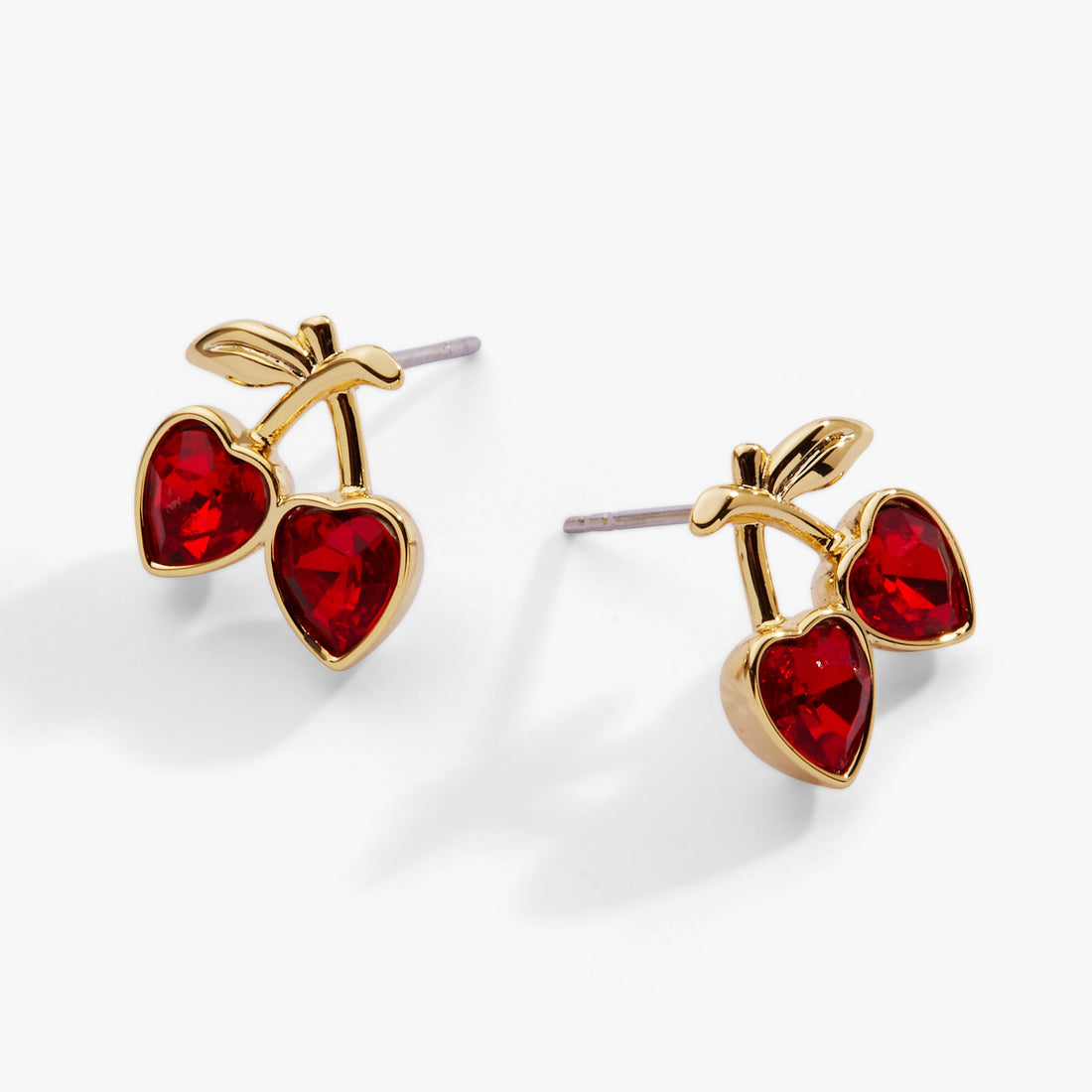 Gold earrings with red heart stones on a white background