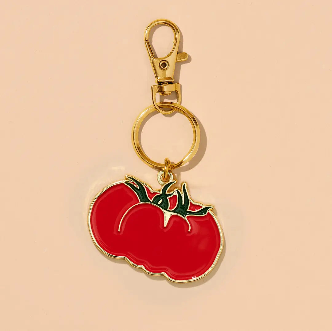 Keychain with a red tomato design on a beige background