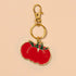 Keychain with a red tomato design on a beige background